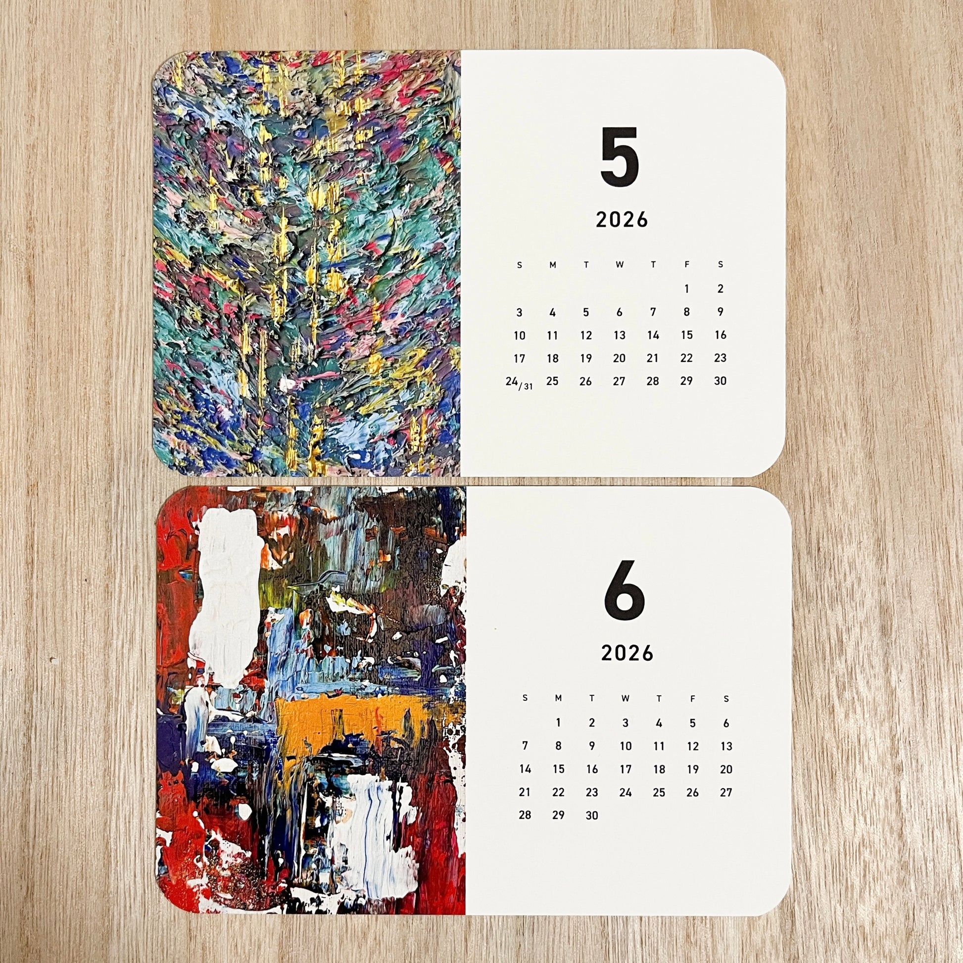 Close-up of Yuka Mitsufuji 2026 calendar showing two months with colorful abstract art / Yuka Mitsufuji 2026年カレンダー、2ヶ月分クローズアップ、カラフルな抽象画作品